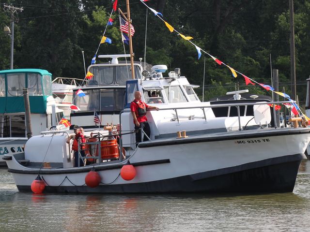 MLB 44334 under way in a marina channel, dressed with signal flags