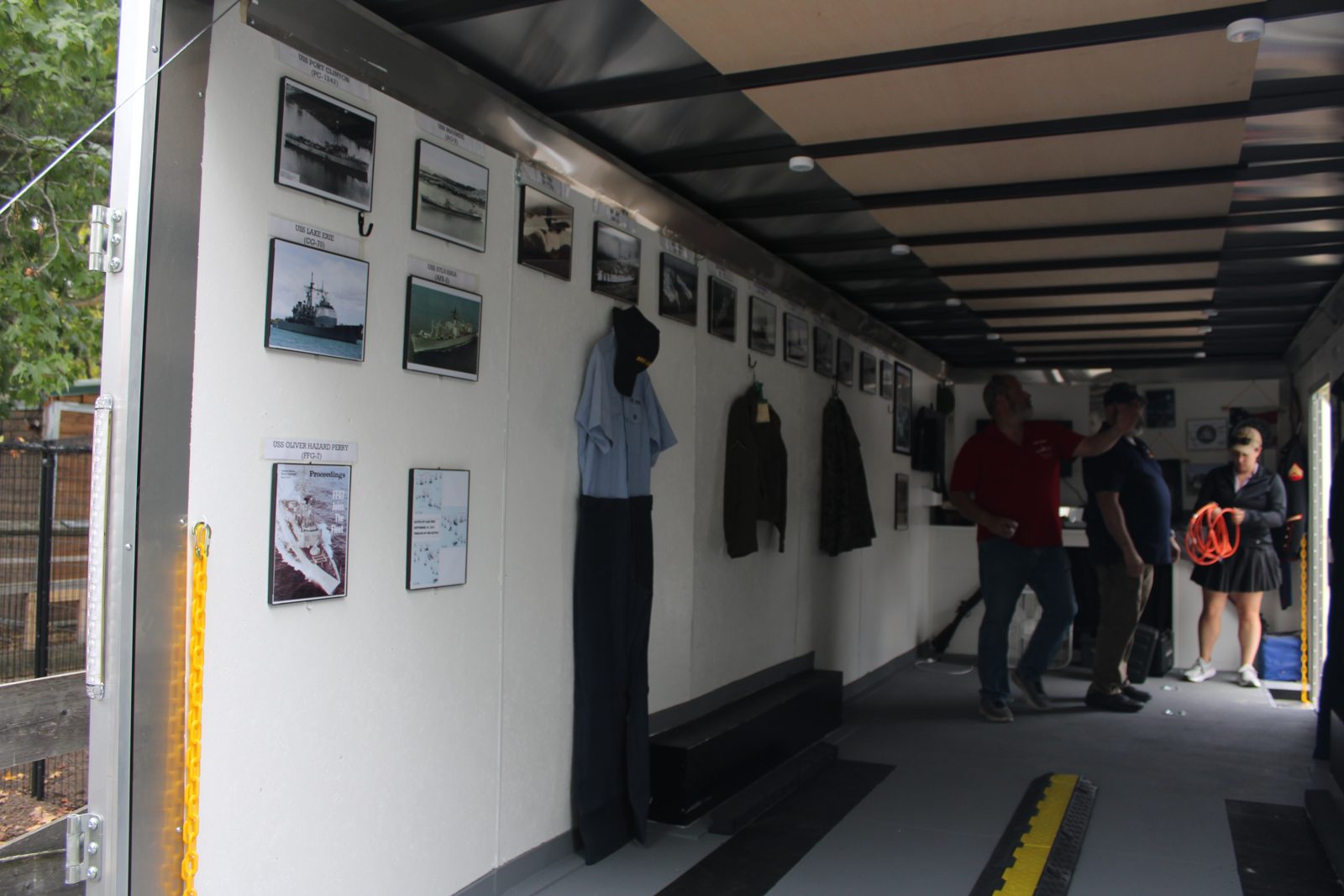 Uniforms and framed photographs displayed inside the Mobile Museum, each with its story