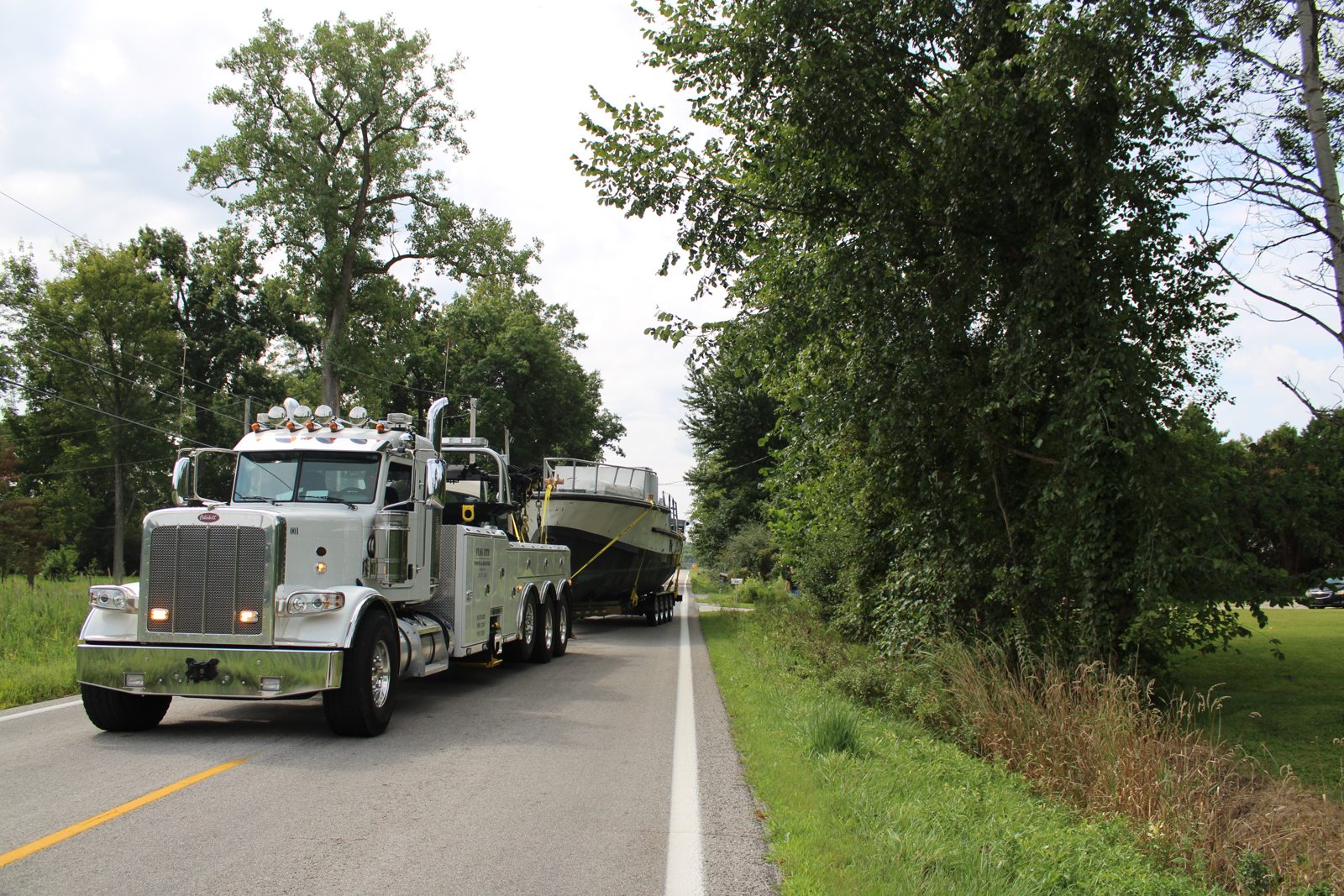 USCG Motor Lifeboat 44334 on her trailer behind a heavy wrecker on the road to her new home