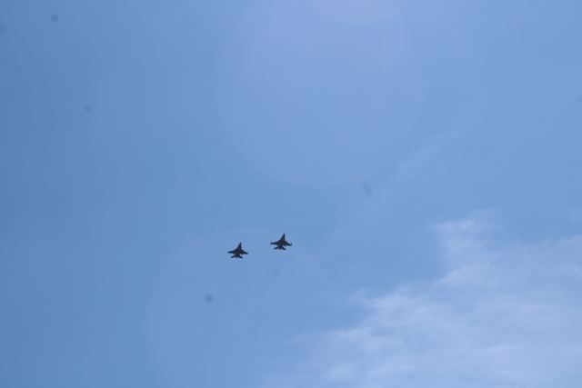 Two military jets flying over in a clear blue sky