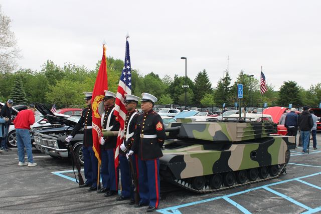 A Marine Corps color guard in dress blues standing beside Lil Abe at a car show