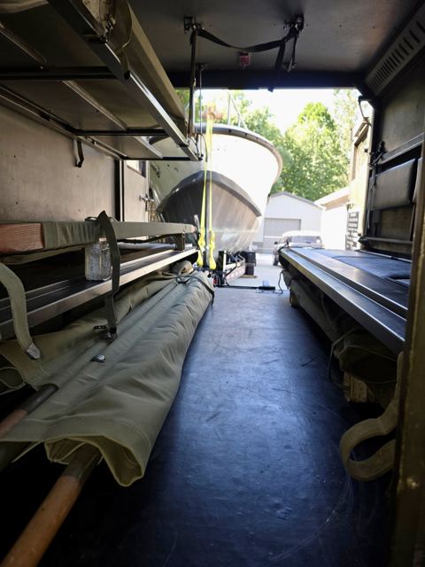 Inside the M725 patient compartment, folded litters along both walls