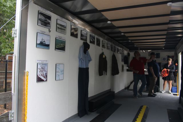 Inside the mobile museum: uniforms, framed photographs and exhibits along both walls