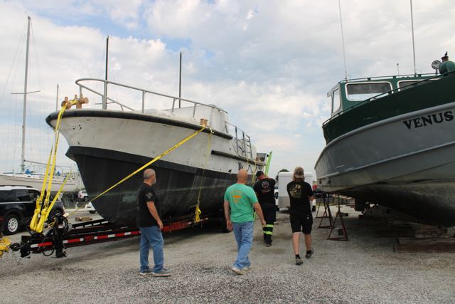 Three volunteers standing beside MLB 44334 on the trailer