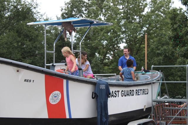 Visitors climbing aboard the surf boat at a public event